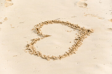 A heart in the sand on the beach.