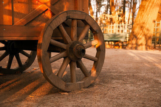 a wooden cart with a round wooden wheel. an old wagon.