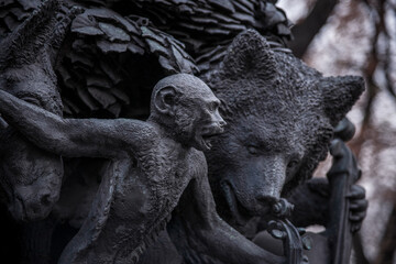 Fototapeta na wymiar black sculpture of a monkey and a bear. a statue in the park.