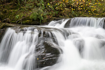 Long exposure of a waterfall flowing through the woods at Watersmeet in Exmoor National Park
