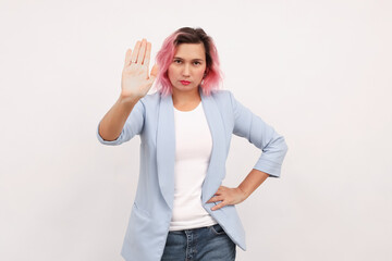 Obraz premium Serious business woman showing stop sign and frowning displeased, telling no, refusing something, white background