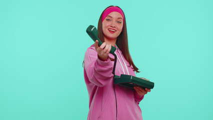 Hey you, call me back. Cheerful teen girl secretary in pink hoodie talking on wired vintage...