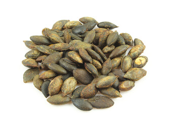 Pile of roasted unshelled pumpkin seeds isolated on white background