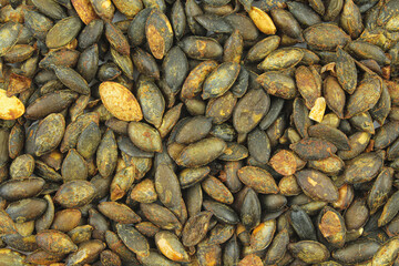 Roasted and peeled pumpkin seeds textured background