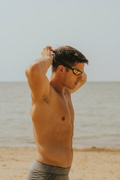 Hombre Joven Adolescente Natacion. Deporte Aire Libre Playa. Natacion Naturaleza. Joven Poniendose Gafas De Natacion. 