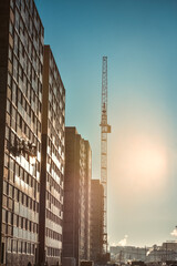 Fototapeta na wymiar Industrial cranes and new multi-storey building