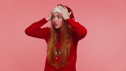 Scared girl in Christmas Santa sweater meeting her own phobia, evidence horror event, screaming, shouting at loud, freaked out isolated on pink background. Happy New Year celebration merry holiday