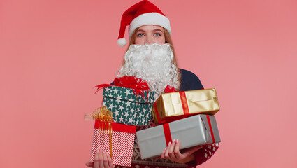 Girl in Christmas fake beard of Santa Claus looking surprised at mount of boxes hands excited by so many holiday gifts, lot of presents. Happy New Year presents shopping sale celebration merry holiday