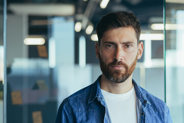 Portrait of startup man with beard, businessman, serious thinking leader looking at camera close...