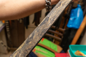 Latin saddler working on handicrafts, belts, bags and wallets on snakeskin leather.