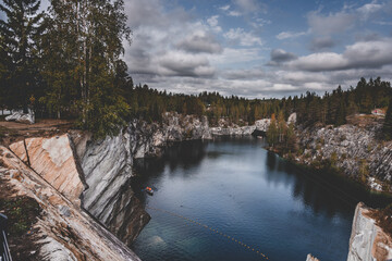 Quarry with marble rocks , forest and river in Karelia