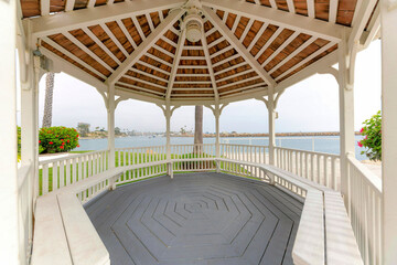 Inside a gazebo with seats and octagon lines on the gray wood flooring at Oceanside, California