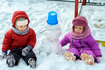 Children's game in snow outside, winter holidays, games and have fun. Little Children Kids Boy and...