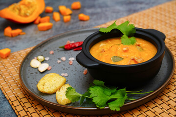 Pumpkin soup. Homemade pumpkin puree soup in a black bowl. - 471565083