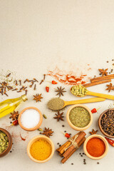 Fototapeta na wymiar A set of spices for cooking curry. Aromatic condiments on light stone concrete background