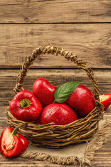Ripe red round peppers in a handmade wicker basket
