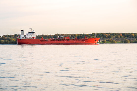 Chemical tanker in navigation at sunset in autumn. A wooded island is in background. Lake Ontario, Canada.