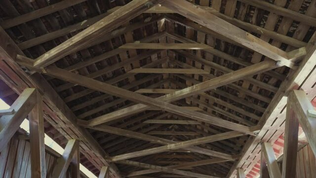 This video shows architectural exposed wood beams inside an old covered bridge.