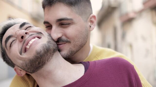 Lgbt gay male couple having tender moment hugging outdoor in the city