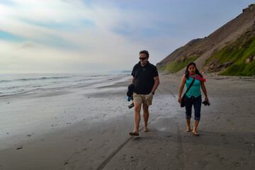 Man and woman, friends walking along the seashore.