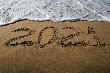 Happy New Year 2021! Written in 2021 on the beach. Happy New Year 2021 is coming sandy concept