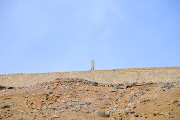 Stone monolith at the top of a stone wall.