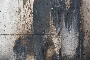 Soiled concrete wall by paint and fire residue, grunge background texture for social issues or architecture themes, copy space