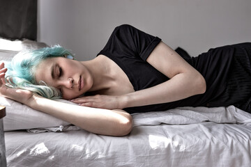Unhappy exhausted woman lying on bed, suffering from headache or migraine, feeling unwell,...