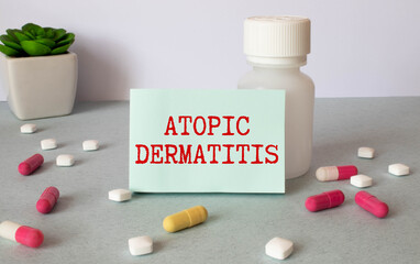 atopic dermatitis, text on a blue background on a white notebook sheet, near the pills and syringe.