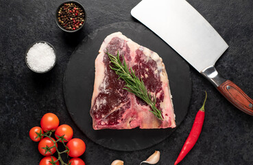 Raw t-bone steak with spices on a stone background. dry-aged steak