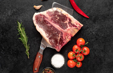 Raw t-bone steak with spices on a stone background. dry-aged steak