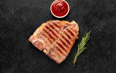 grilled t-bone steak with spices on a stone background