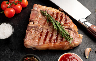 grilled t-bone steak with spices on a stone background