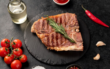 grilled t-bone steak with spices on a stone background