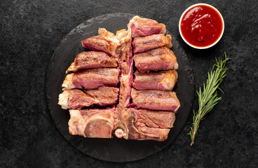 Fototapeta na wymiar grilled t-bone steak with spices on a stone background