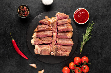 grilled t-bone steak with spices on a stone background
