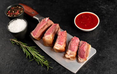 grilled beef slices on a knife on a stone background