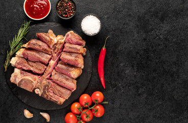 grilled t-bone steak with spices on a stone background with copy space for your text