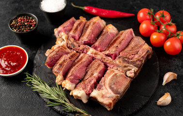 grilled t-bone steak with spices on a stone background