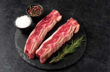 raw marbled beef ribs on stone background