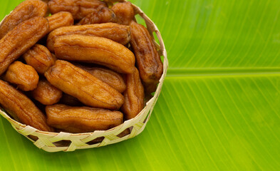 Sun-dried bananas in bamboo basket on bannana leaf