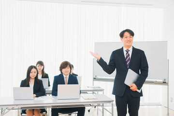 セミナーの講師とスーツ姿の男女（男性）
