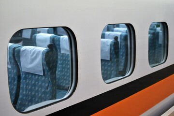 Empty blue cushioned subway train seats as seen from the train platform outside the train window