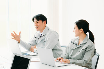 Fototapeta premium 会議をする作業着をきた会社員 