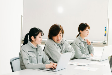 Fototapeta premium 会議をする作業着をきた会社員（考える・3人） 