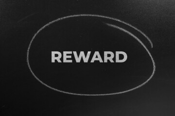 The Word reward Written On The Chalkboard. REWARD concept background.
