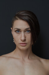 portrait of a blue-eyed Russian brunette on a black background in the studio