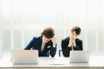 困るスーツ姿の男女
