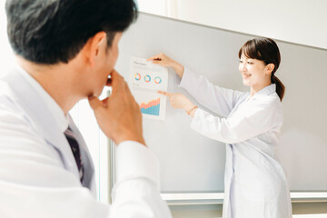 Fototapeta premium 会議をする白衣姿の男女 