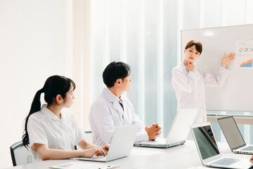 Obraz premium 会議する白衣姿の男女（考える女医） 